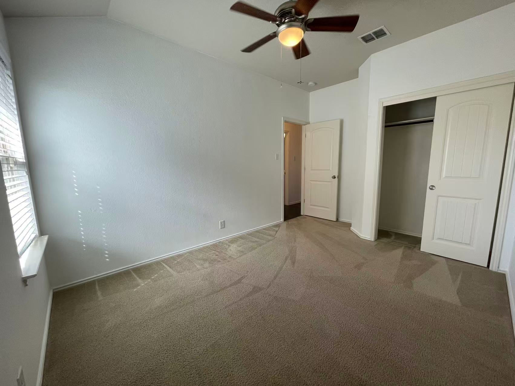 457 Dragon Ridge Road Buda, TX 78610 - Photo 12 of 29 Unfurnished bedroom featuring carpet floors, a ceiling fan, and a closet