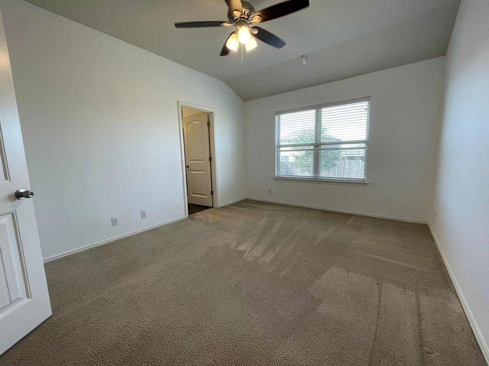 457 Dragon Ridge Road Buda, TX 78610 - Photo 14 of 29 Carpeted empty room with a ceiling fan and vaulted ceiling