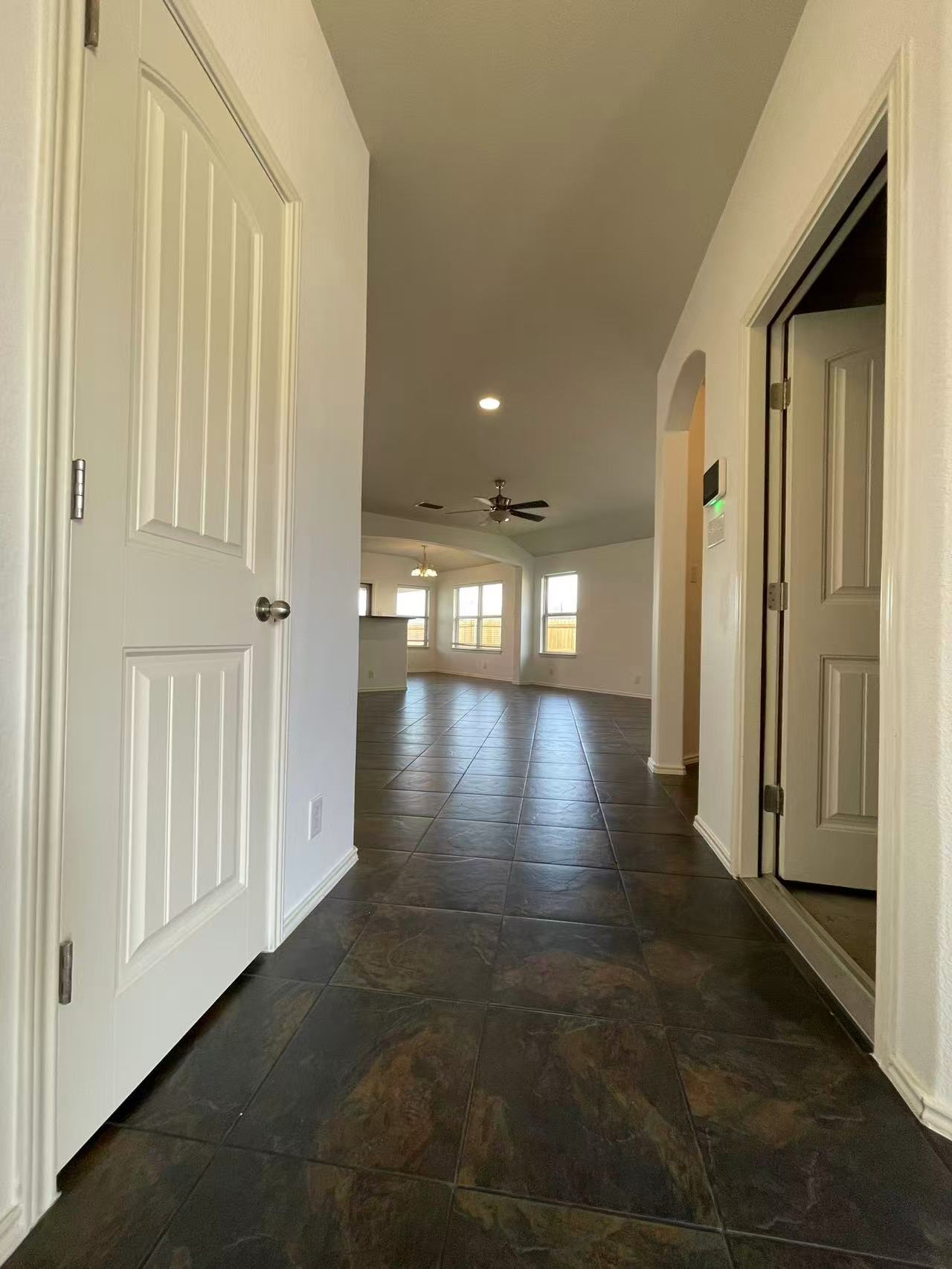 457 Dragon Ridge Road Buda, TX 78610 - Photo 4 of 29 Corridor with arched walkways, recessed lighting, and dark tile patterned floors