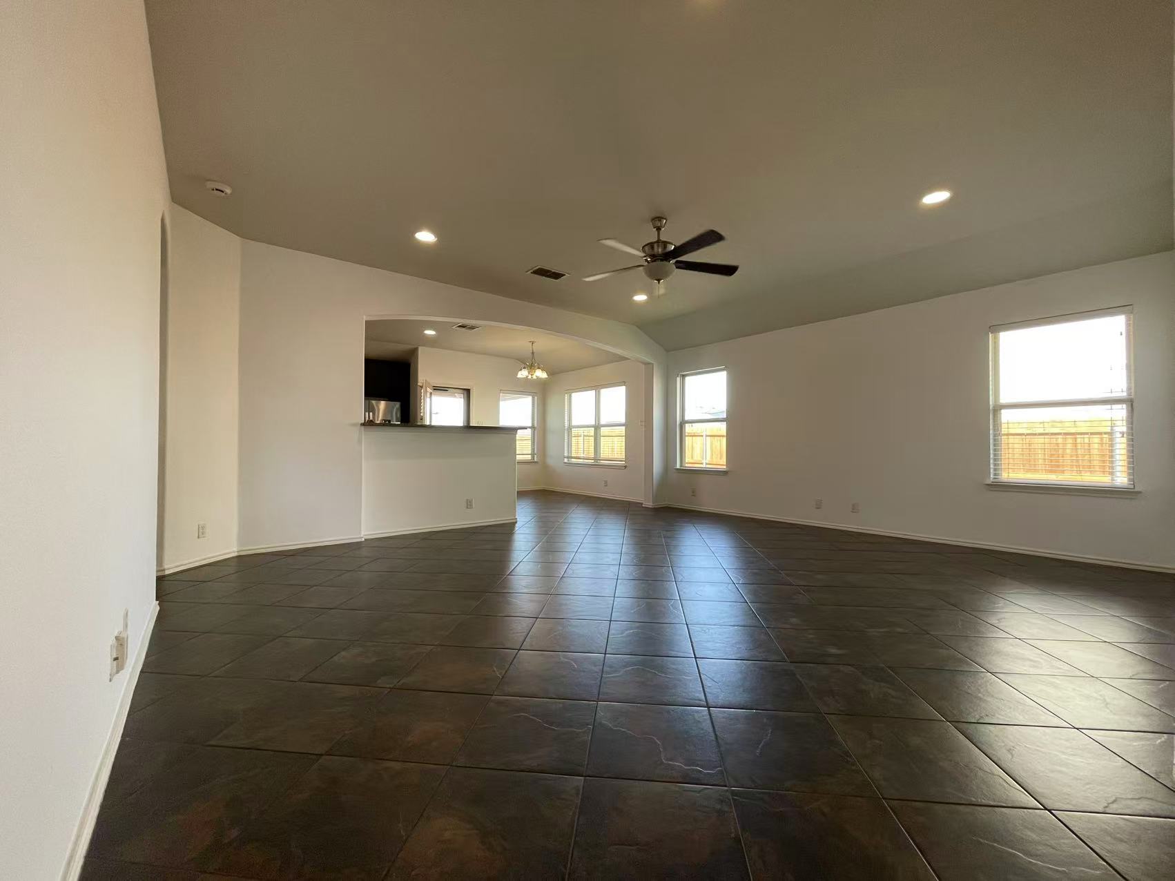 457 Dragon Ridge Road Buda, TX 78610 - Photo 8 of 29 Unfurnished living room featuring recessed lighting, ceiling fan, arched walkways, and dark tile patterned flooring