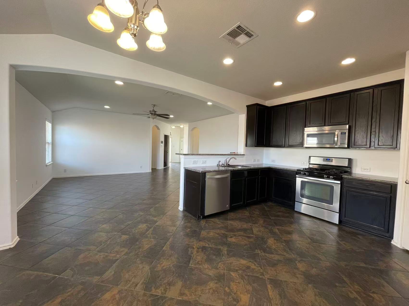 457 Dragon Ridge Road Buda, TX 78610 - Photo 29 of 29 Kitchen with stainless steel appliances, open floor plan, arched walkways, a peninsula, and vaulted ceiling