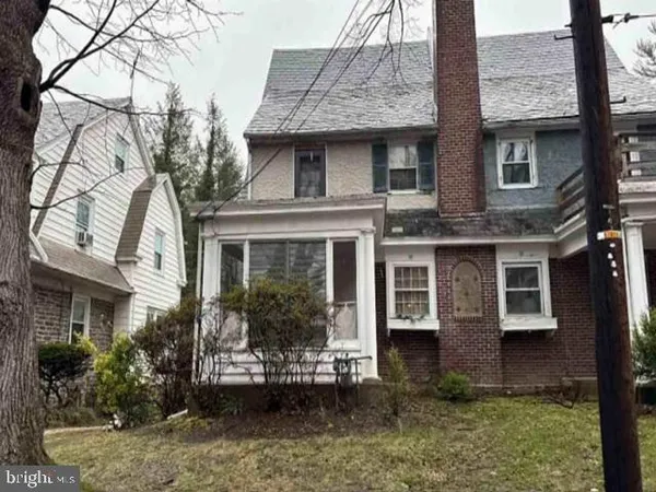 a view of a brick house with many windows and plants
