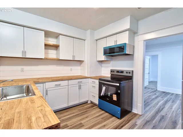 a kitchen with stainless steel appliances granite countertop a stove a sink and a microwave