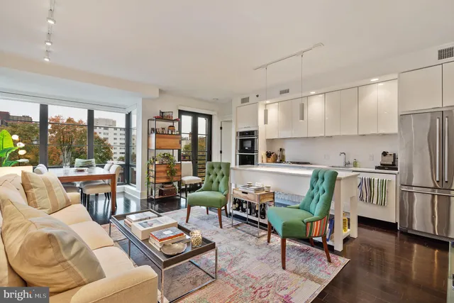 a front view of a building with lot of cars and trees