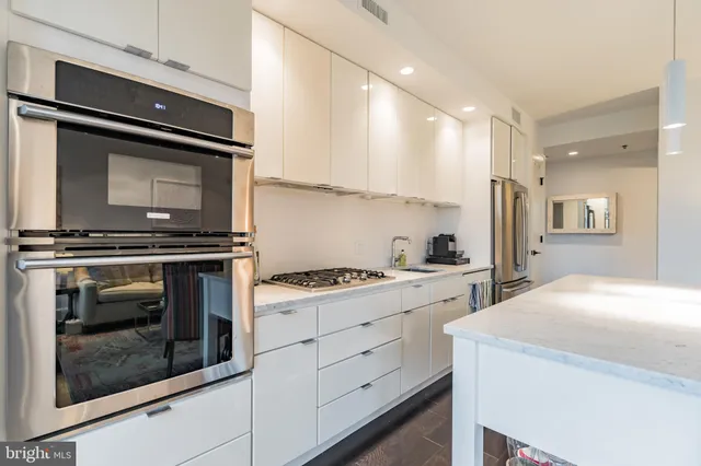 a living room with furniture a flat screen tv and kitchen view
