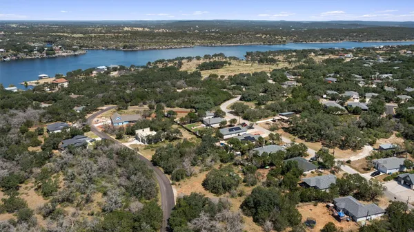 an aerial view of a residential houses with outdoor space and ocean view