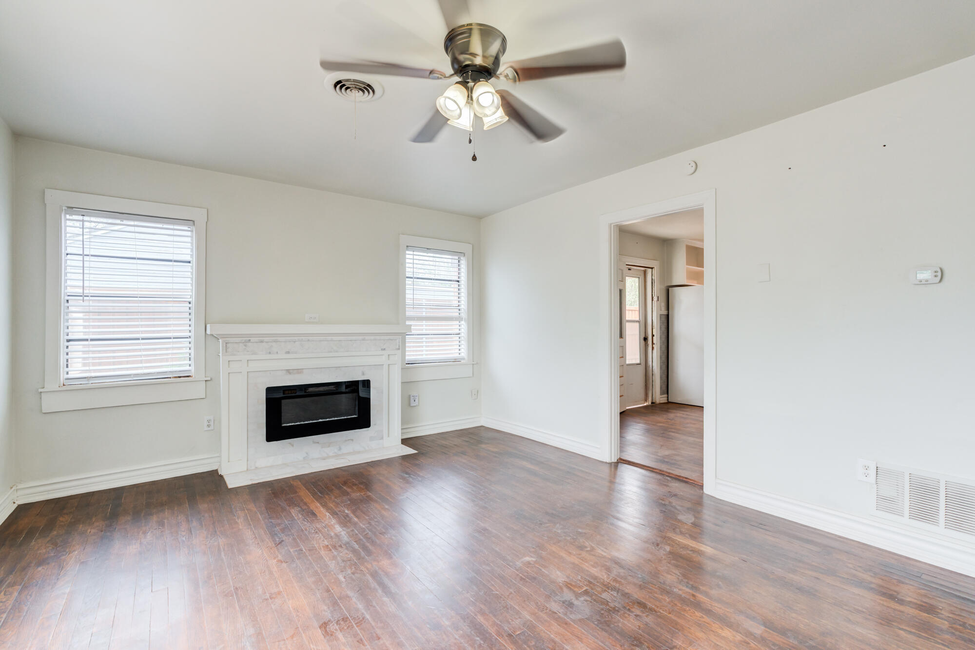 2308 30th Street Lubbock, TX 79411 - Photo 5 of 21 an empty room with windows fireplace and a sink