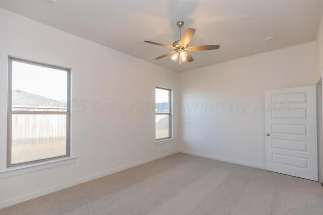 a view of an empty room with a chandelier fan
