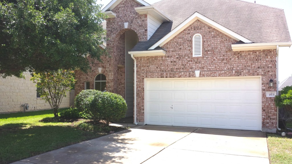 a view of a brick house with a yard