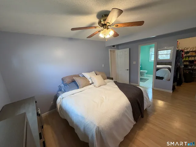 a bed sitting in a bedroom next to a window with a chandelier