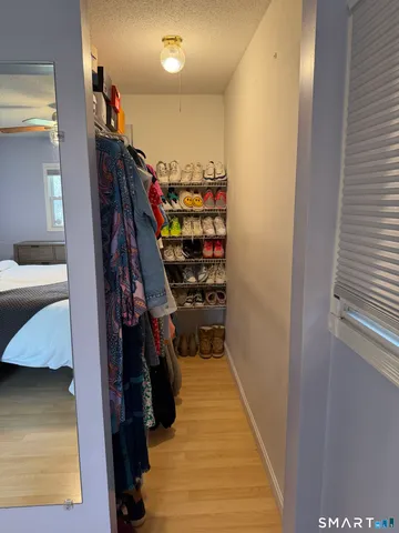a view of walk in closet with clothes and shoes