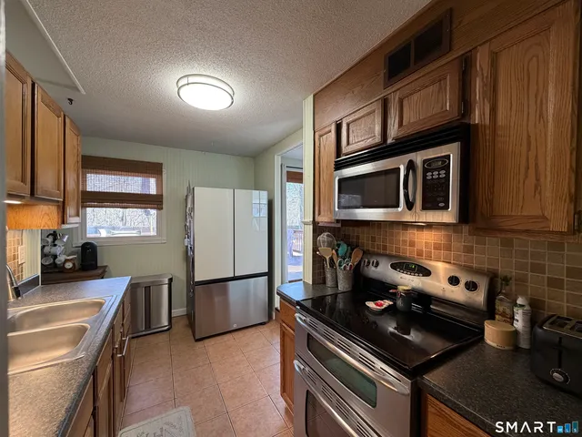 a kitchen with stainless steel appliances granite countertop a refrigerator and a stove top oven
