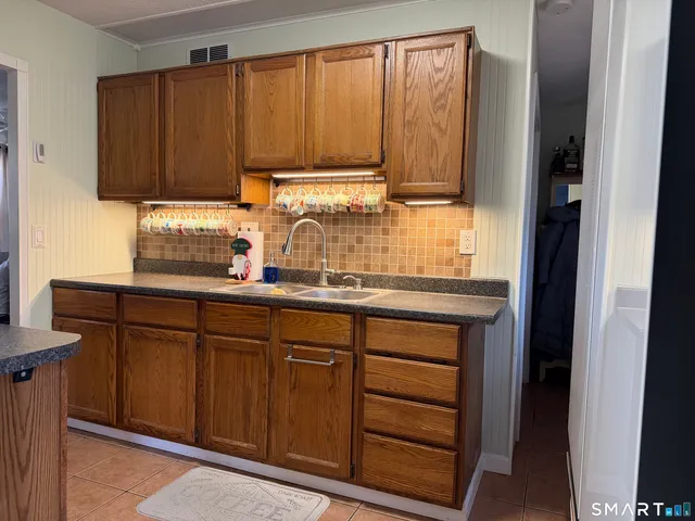 a kitchen with granite countertop wooden cabinets and white appliances