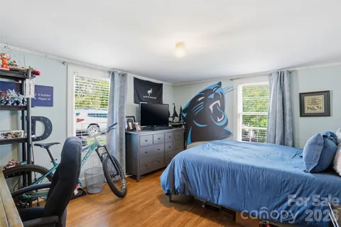 a bedroom with a bed and a flat tv screen on the dresser