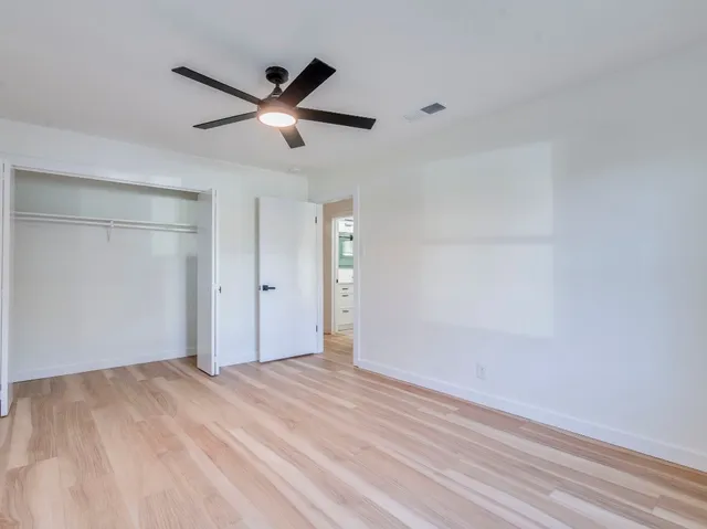 a view of a livingroom with a ceiling fan and wooden floor