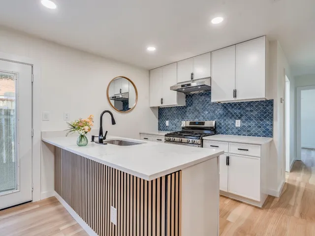 a kitchen with stainless steel appliances granite countertop a stove a sink and a refrigerator