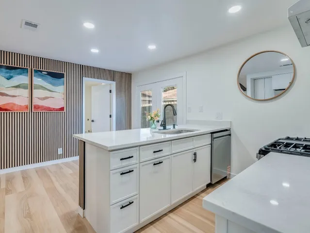 a spacious bathroom with a granite countertop sink a mirror and a vanity