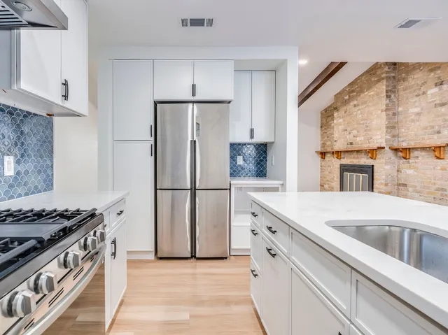 a kitchen with a stove a refrigerator and a sink