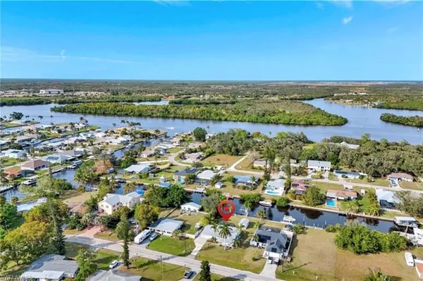 an aerial view of a city with lots of residential buildings and ocean view in back