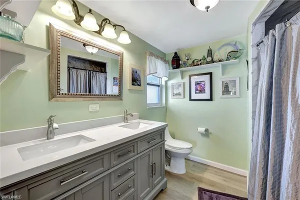 a bathroom with a double vanity sink mirror and toilet