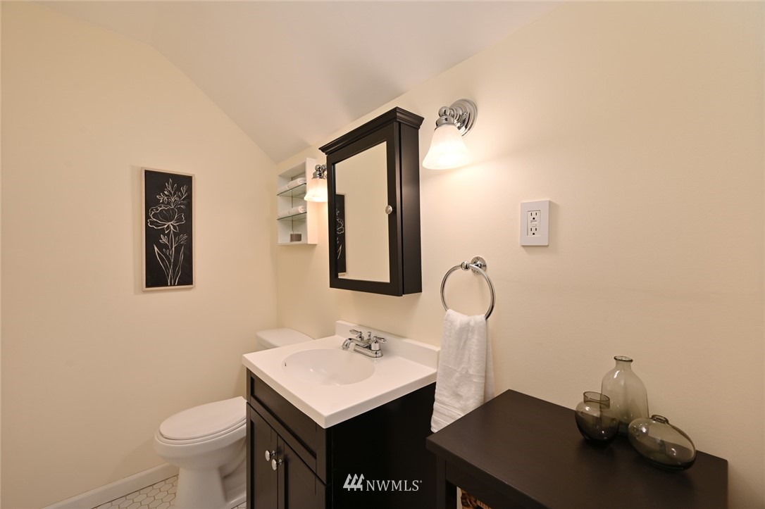 1142 North 78th Street Seattle, WA 98103 - Photo 22 of 24 a bathroom with a sink a toilet and mirror