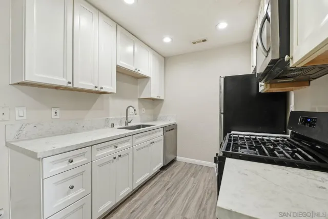 a kitchen with stainless steel appliances a sink stove and cabinets