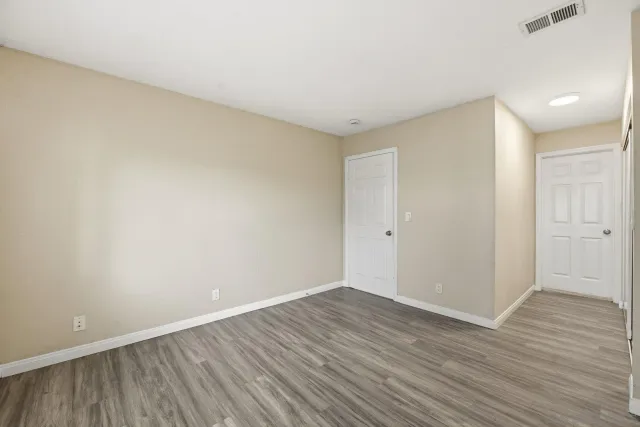a view of an empty room with wooden floor
