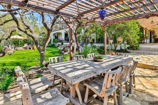 a view of patio with table and chairs and a large tree