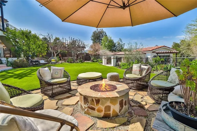 a view of a patio with table and chairs under an umbrella