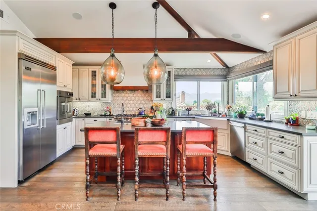 a kitchen with stainless steel appliances granite countertop a sink and a refrigerator
