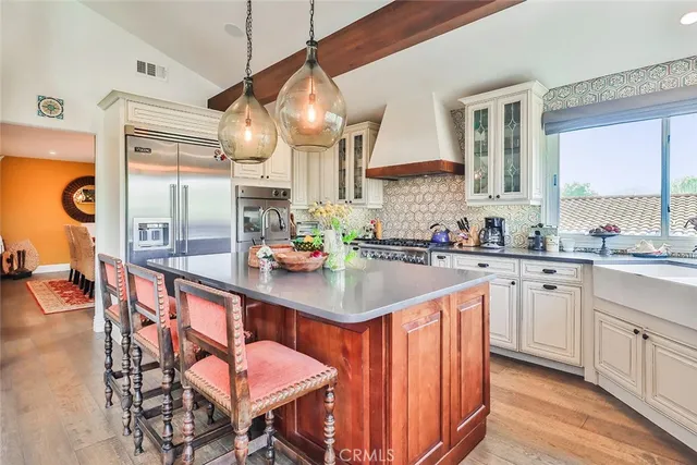a kitchen with stainless steel appliances granite countertop a sink a stove and a refrigerator