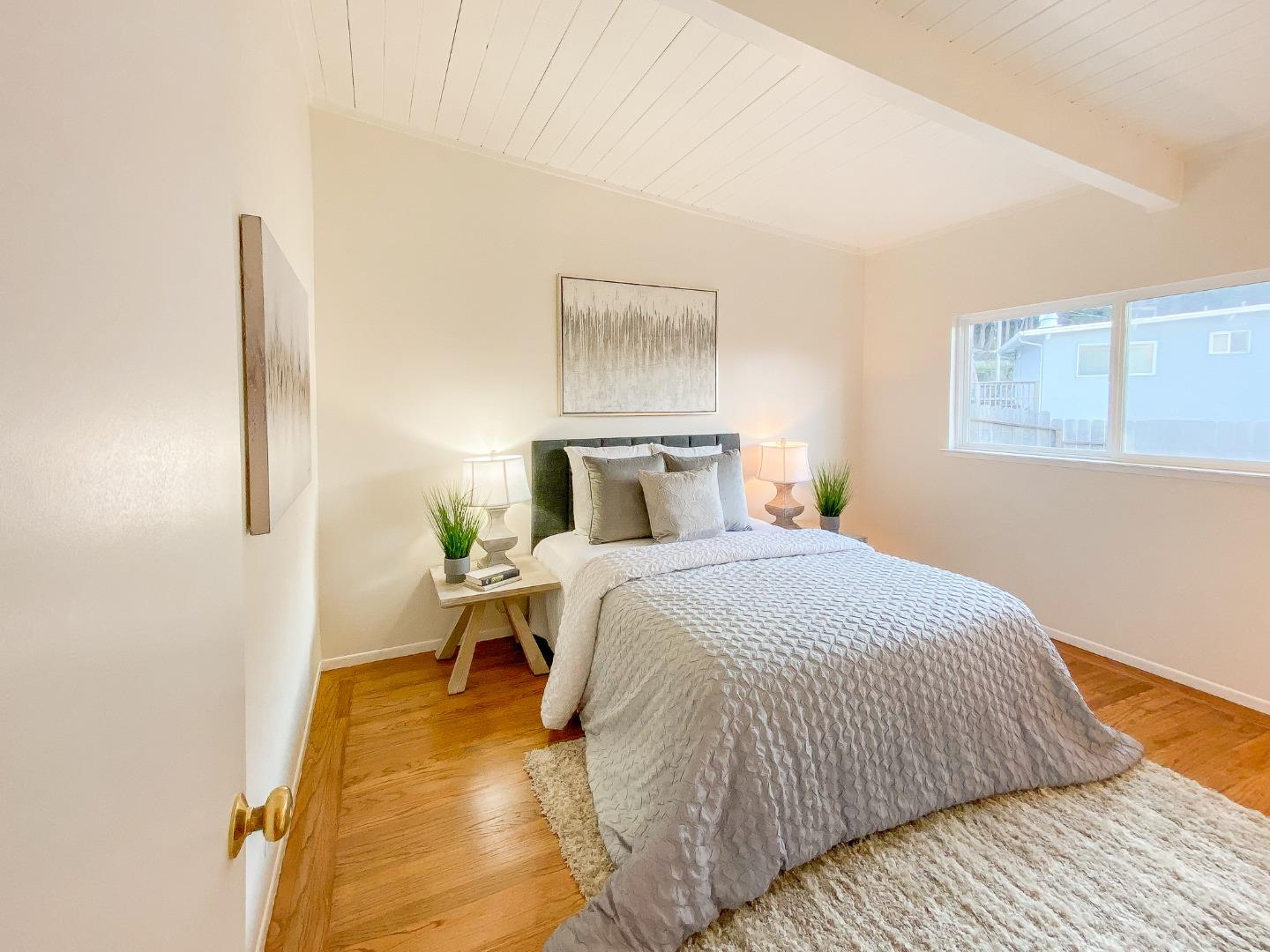 266 Hillside Drive Pacifica, CA 94044 - Photo 28 of 37 a bedroom with a bed and wooden floor