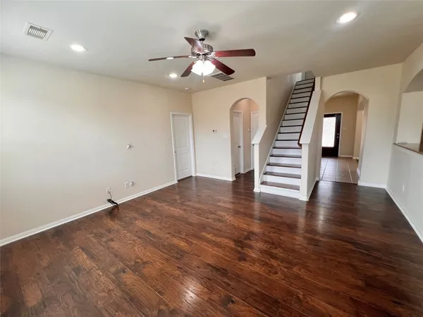 an empty room with wooden floor and staircase