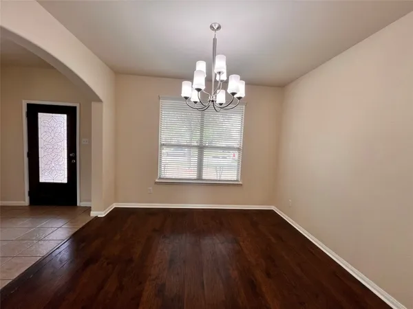 a view of a room with wooden floor chandelier and window
