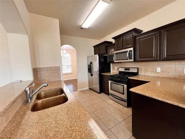 a kitchen with stainless steel appliances granite countertop a stove and a sink