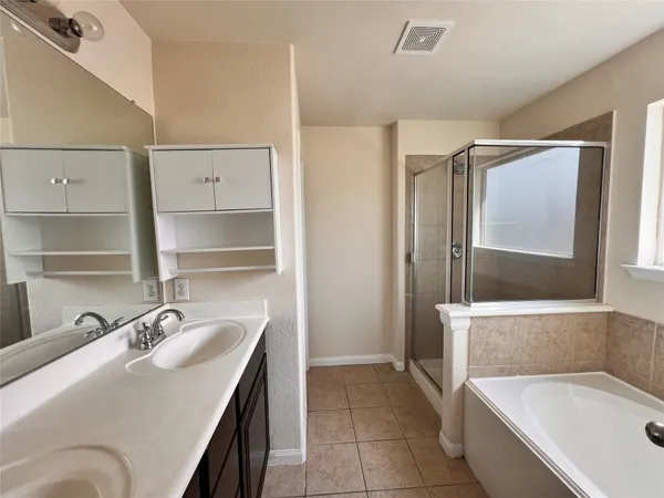 a bathroom with a tub sink and mirror