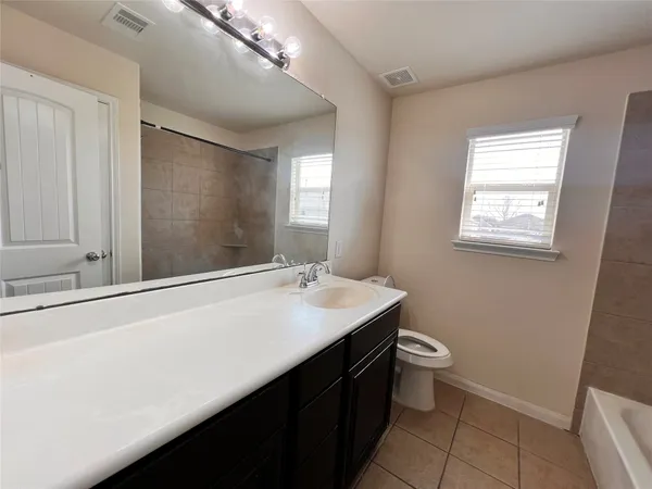 an empty room with a window and a ceiling fan