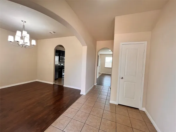 an empty room with wooden floor and staircase