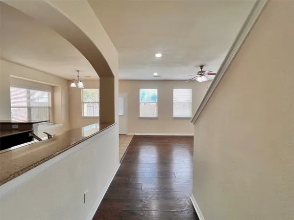 a view of a hallway with wooden floor and staircase