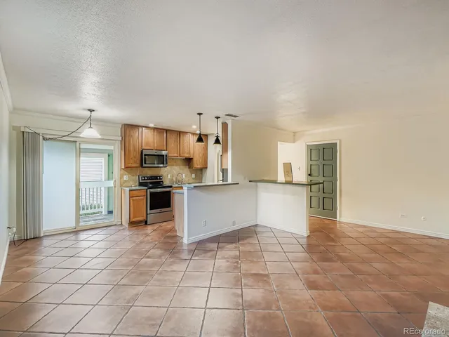 a large kitchen with granite countertop a large counter top and stainless steel appliances