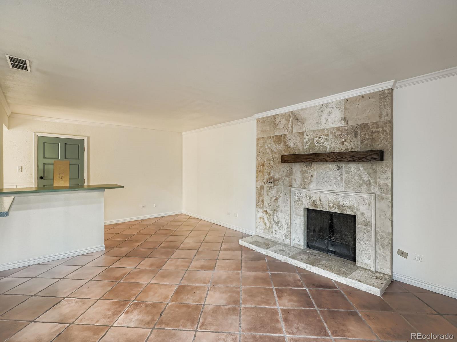 3420 South Locust Street, Unit D Denver, CO 80222 - Photo 4 of 16 a view of an empty room with a fireplace and a window