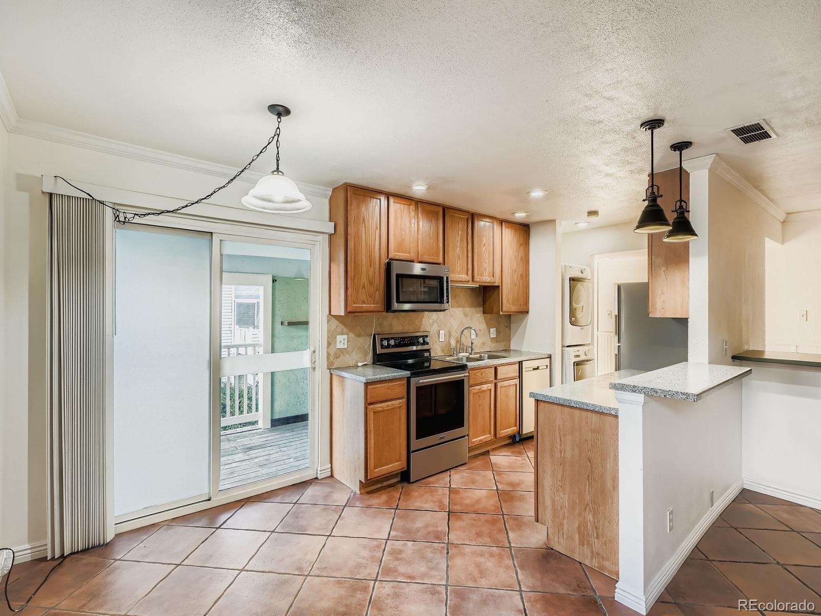 3420 South Locust Street, Unit D Denver, CO 80222 - Photo 5 of 16 a kitchen with stainless steel appliances granite countertop a refrigerator and a sink