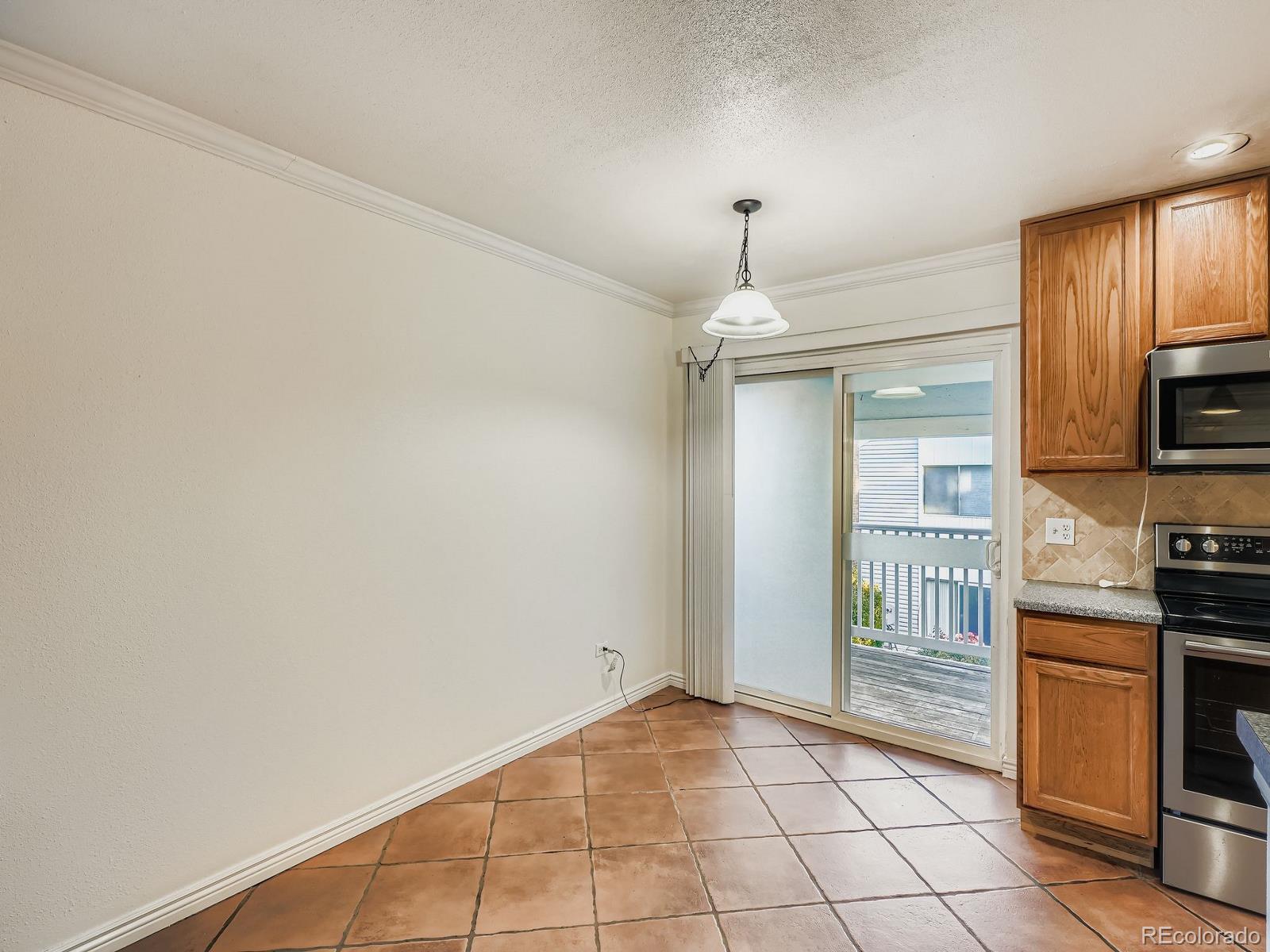 3420 South Locust Street, Unit D Denver, CO 80222 - Photo 7 of 16 a kitchen with granite countertop a stove a sink and a refrigerator