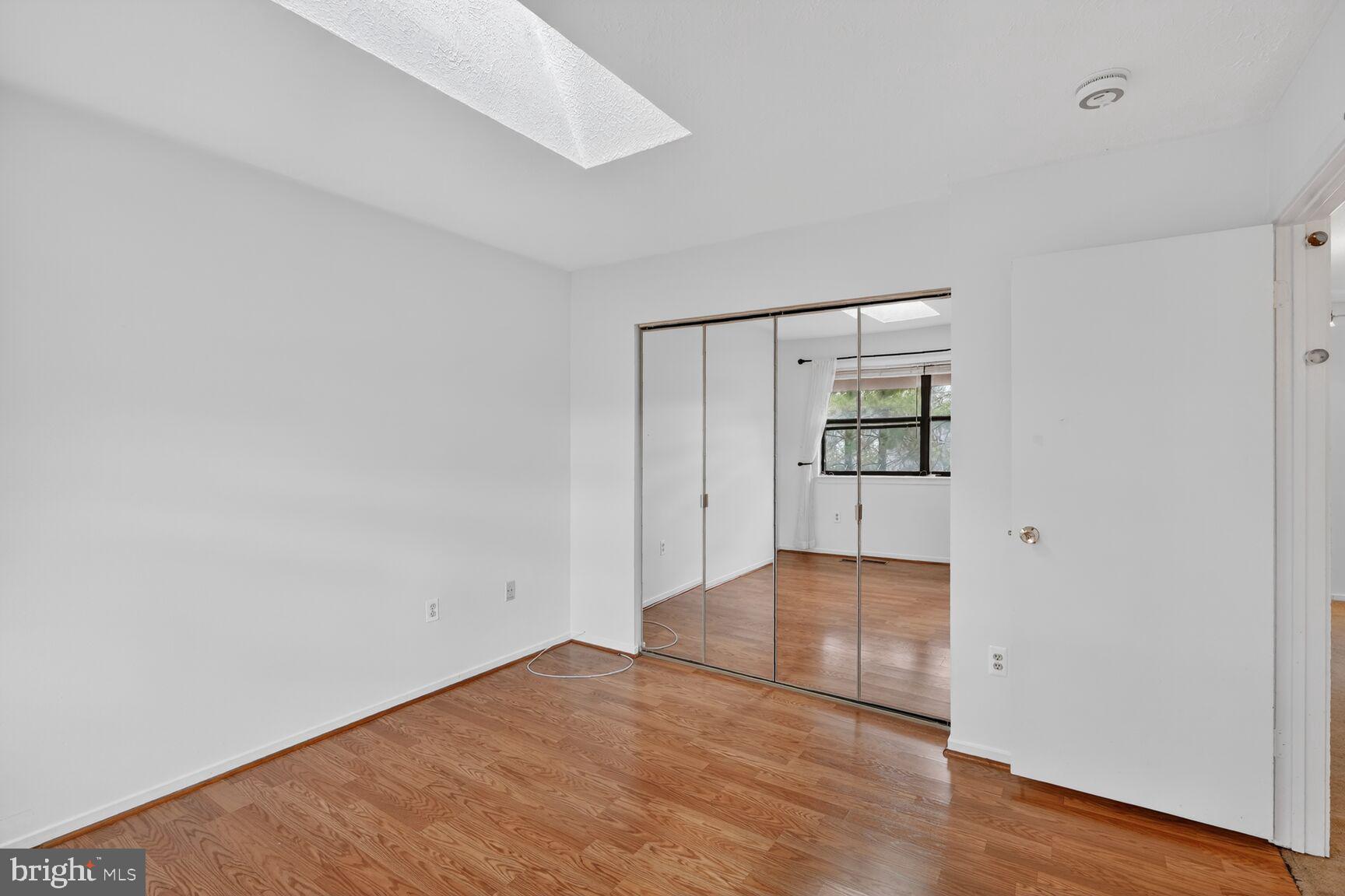7505 Weather Worn Way, Unit E Columbia, MD 21046 - Photo 21 of 32 an empty room with wooden floor and door