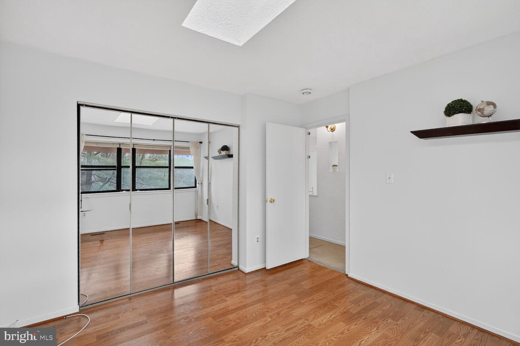 7505 Weather Worn Way, Unit E Columbia, MD 21046 - Photo 22 of 32 an empty room with wooden floor and windows
