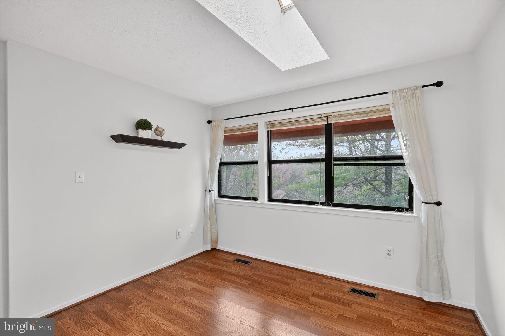 7505 Weather Worn Way, Unit E Columbia, MD 21046 - Photo 23 of 32 an empty room with wooden floor and windows