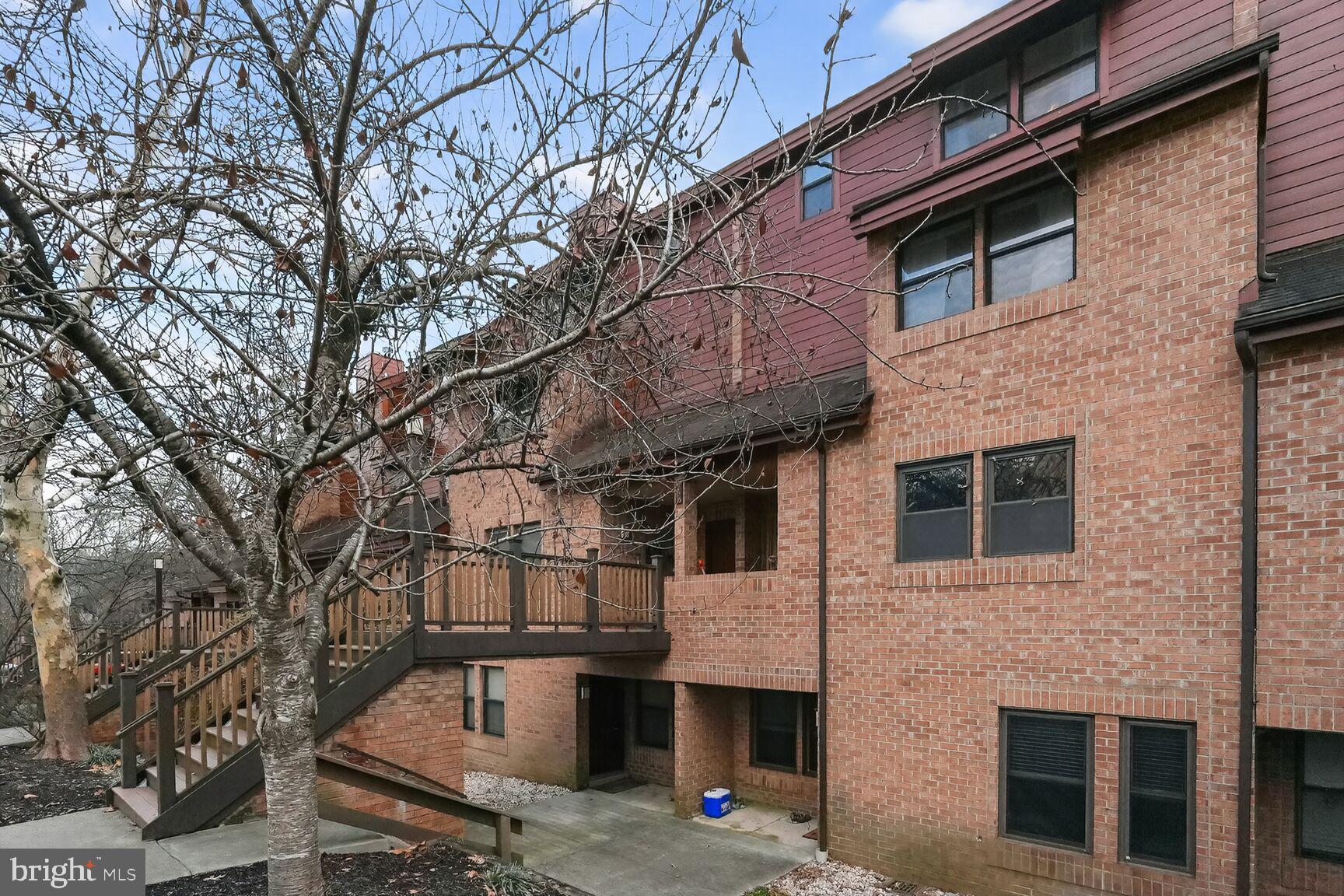 7505 Weather Worn Way, Unit E Columbia, MD 21046 - Photo 32 of 32 a front view of a building with large trees