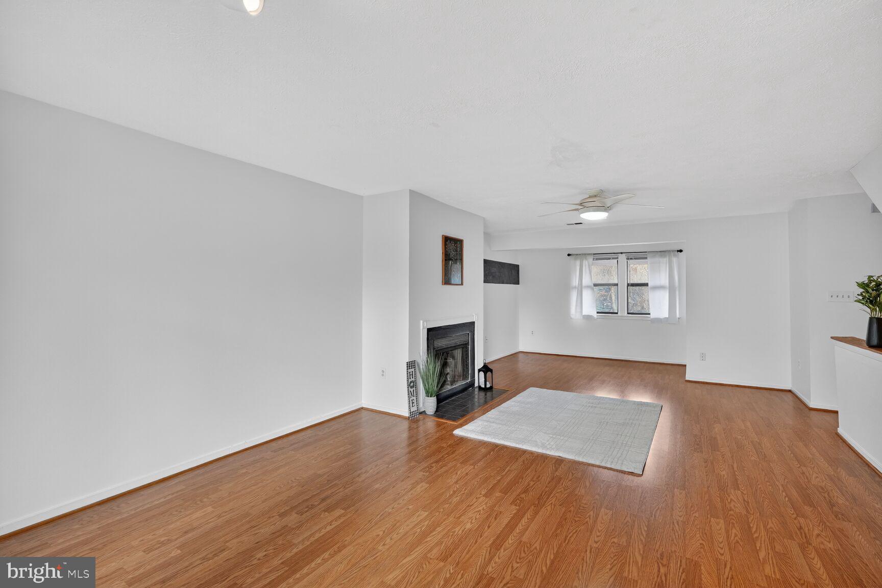 7505 Weather Worn Way, Unit E Columbia, MD 21046 - Photo 7 of 32 a view of a livingroom with wooden floor and a fireplace