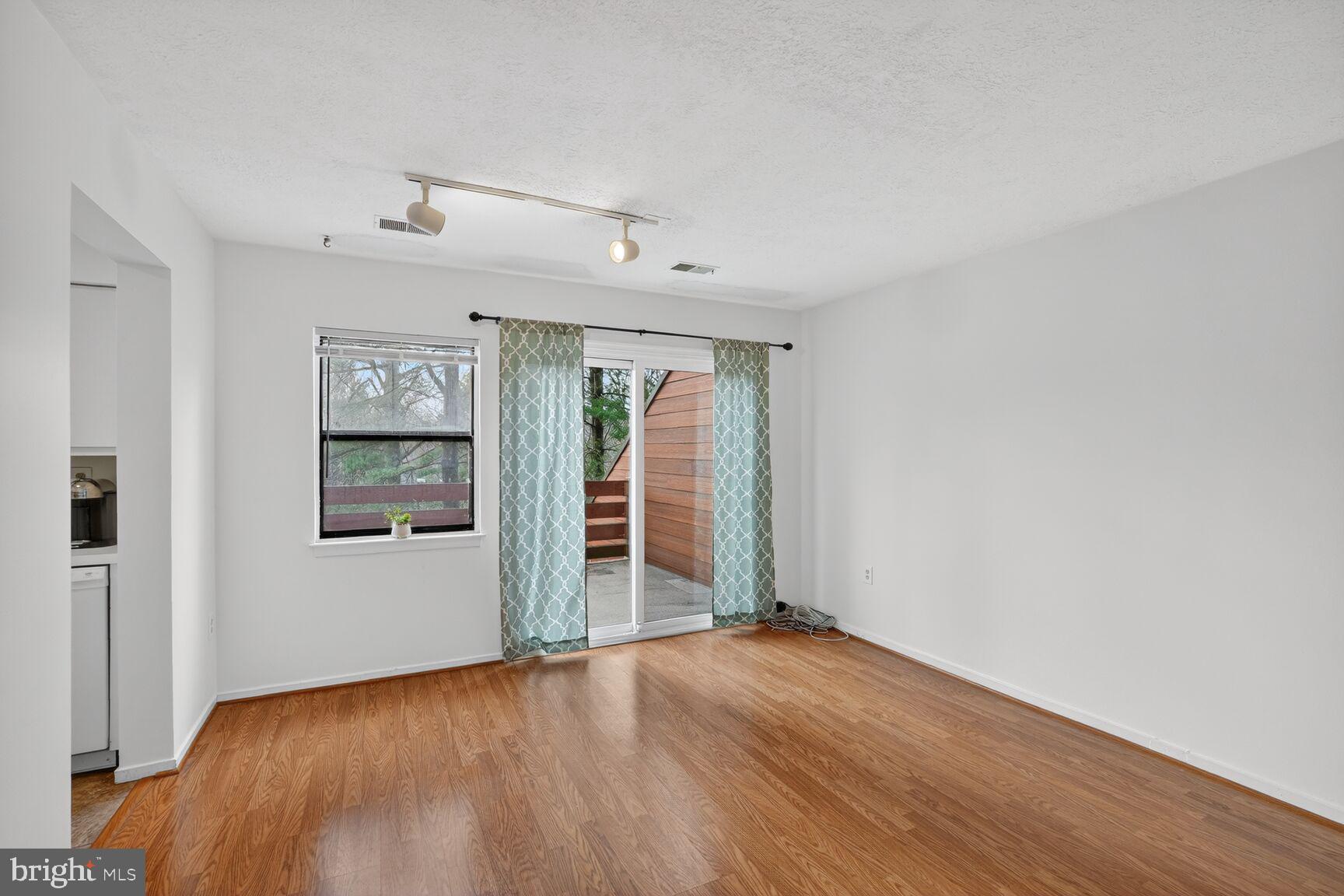 7505 Weather Worn Way, Unit E Columbia, MD 21046 - Photo 8 of 32 an empty room with wooden floor and windows