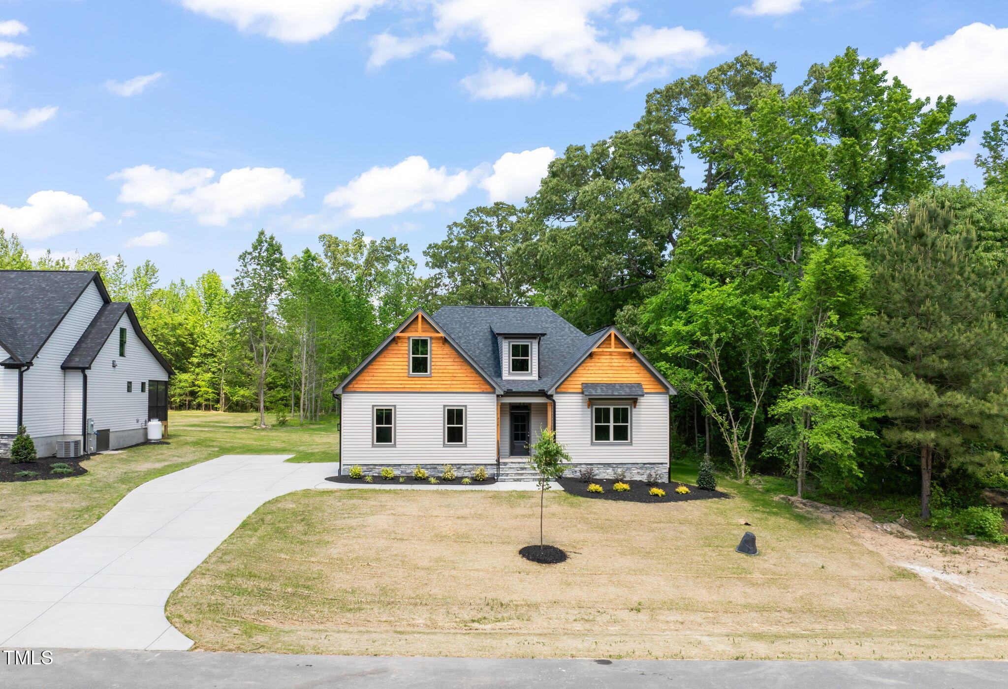 a front view of a house with a yard and trees
